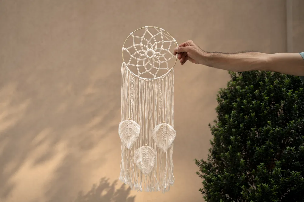 hand-holding-dream-catcher-outdoors